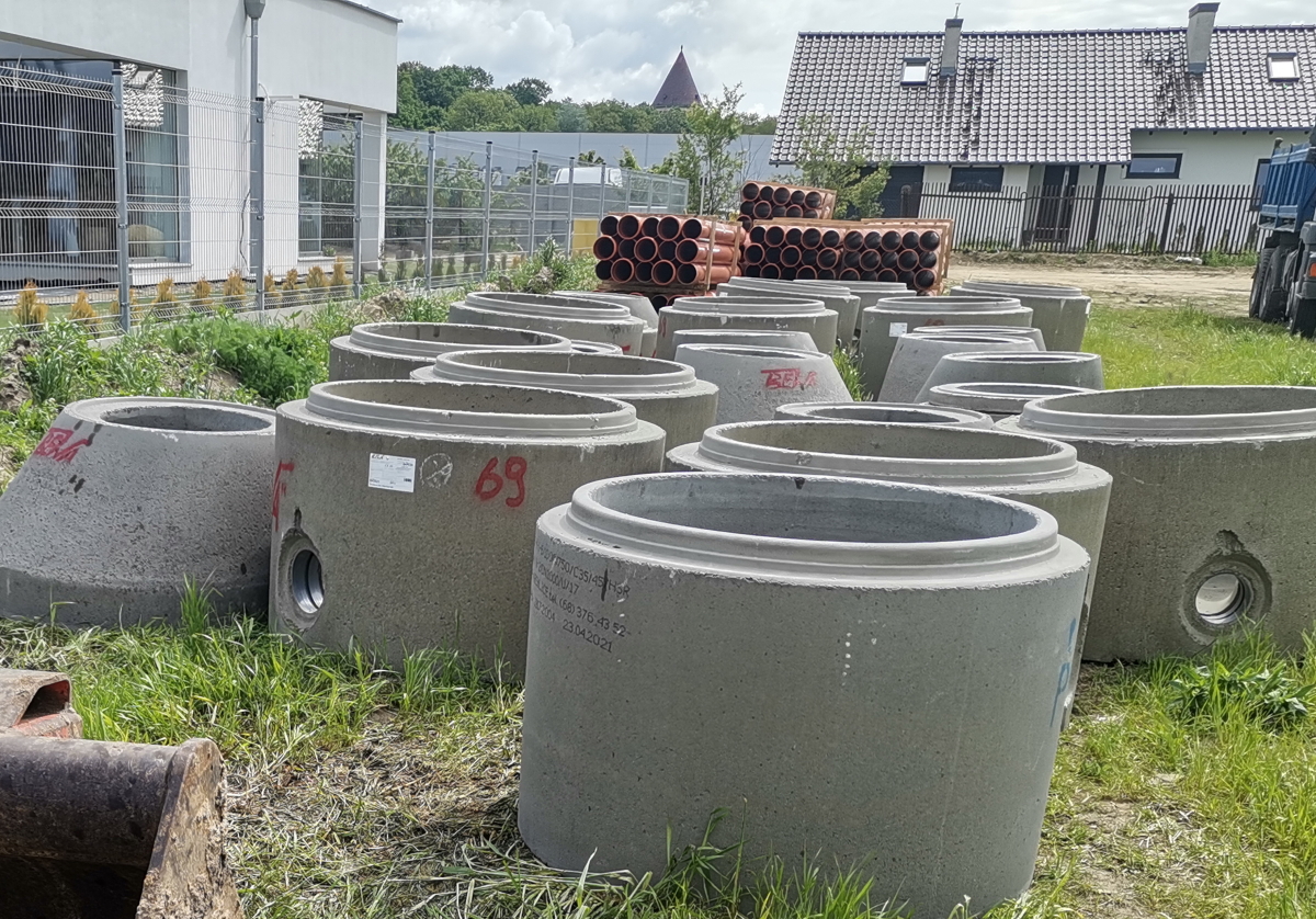na zdjęciu kregi betonowe i rury do budowy kanalizacji