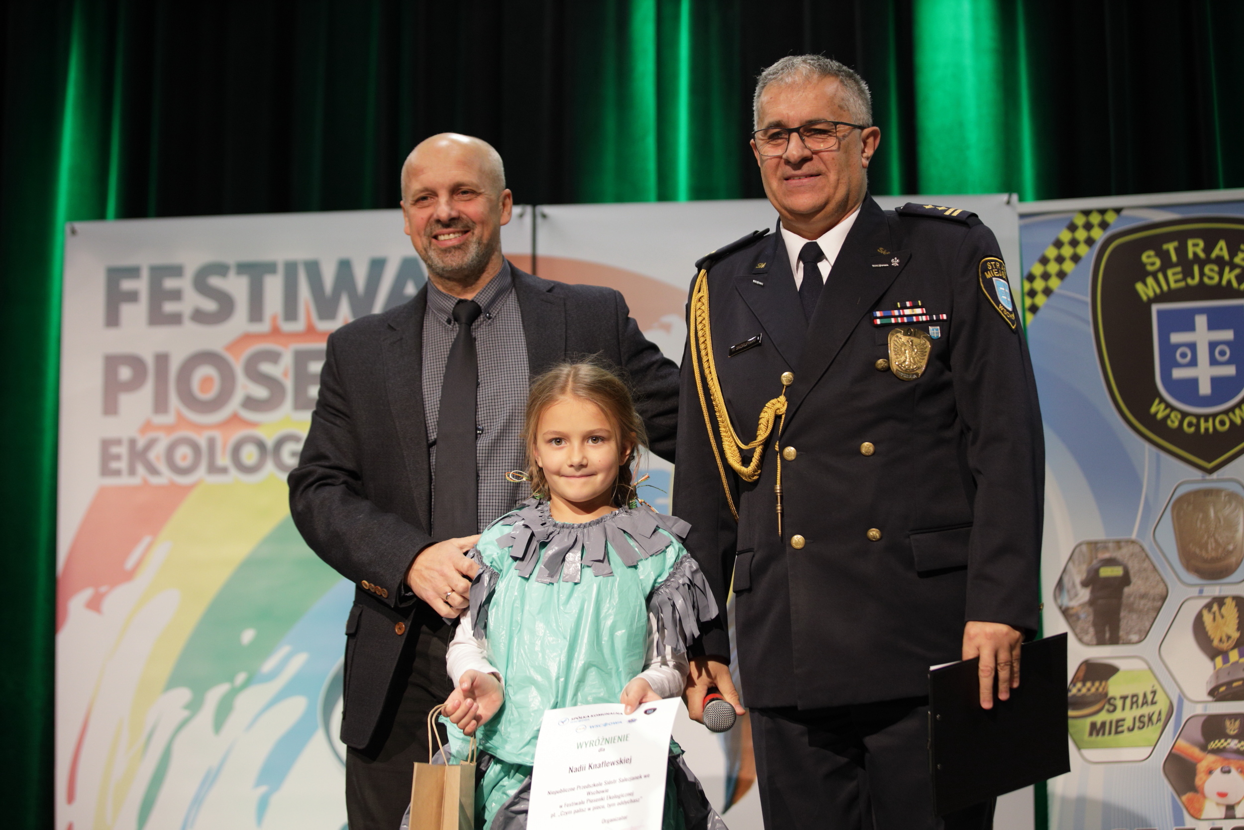 na zdjęciu Prezes Zarzadu spółki Krzysztof Kołodziejczyk, Komendant Straży Miejskiej Witold Skorupiński, i uczestniczka festiwalu podczas wreczenia nagród