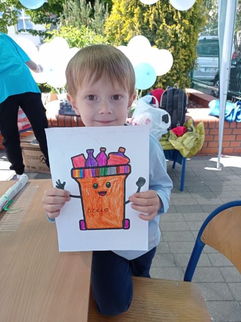 dziecko ze swoja pracą plastyczna