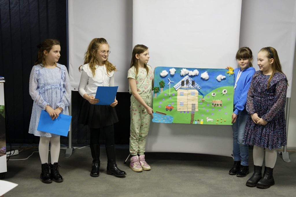 na zdjęciu uczniowie ze swoja pracą