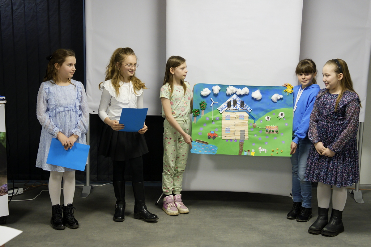 na zdjęciu uczniowie ze swoja pracą